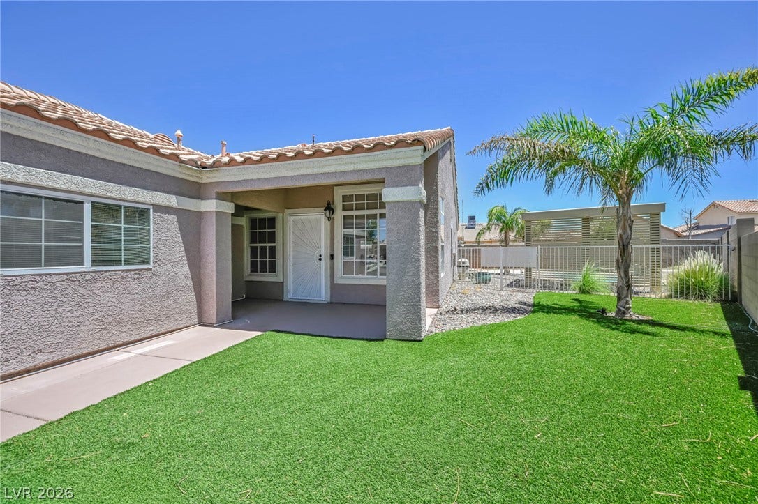 A private yard with artificial turf and a covered patio offers outdoor relaxation.