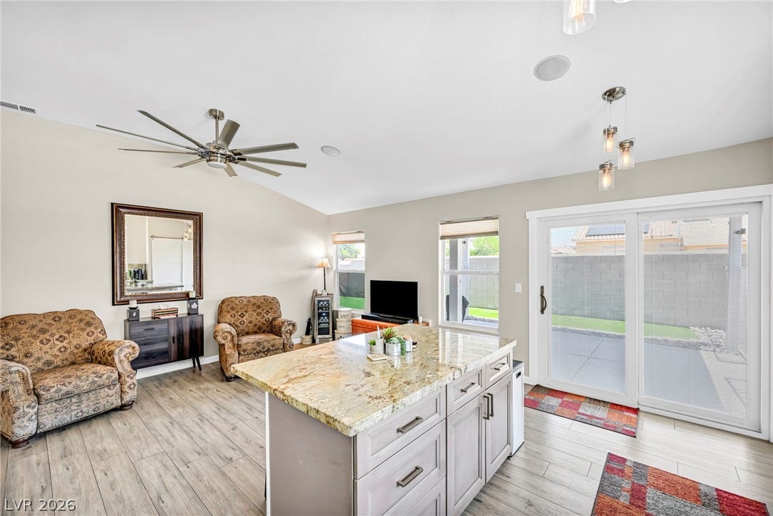 Granite counters grace the spacious kitchen island, complemented by sleek flooring and outdoor access.
