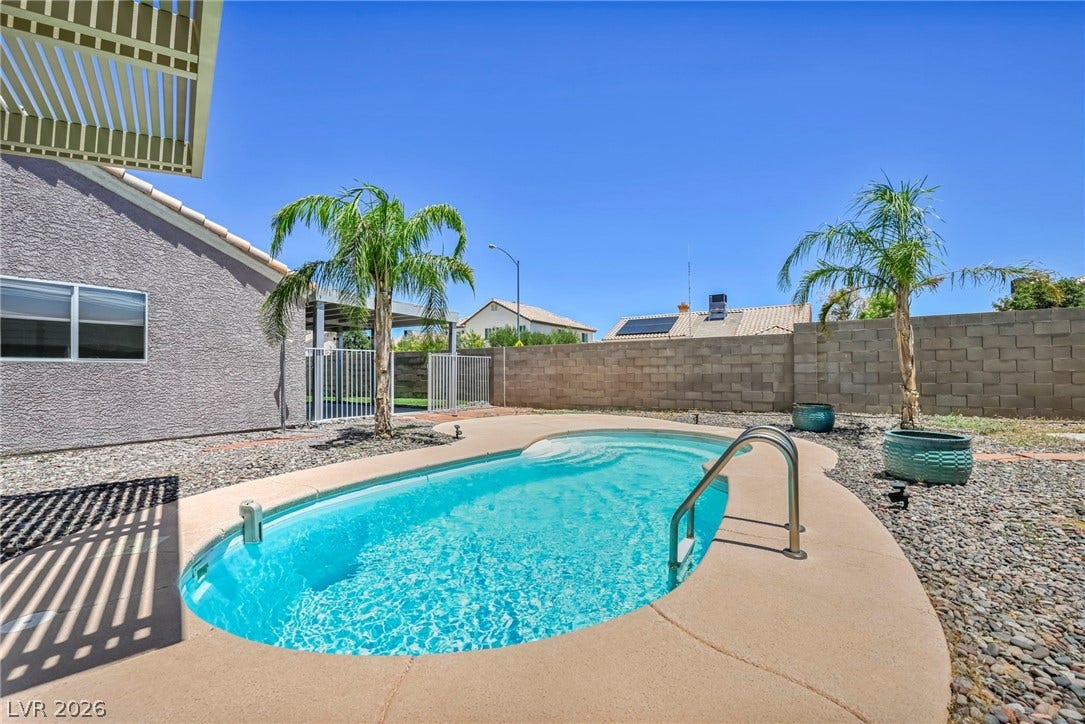 A tranquil oasis awaits, complete with a private pool, lush palm trees, and ample space for outdoor relaxation.