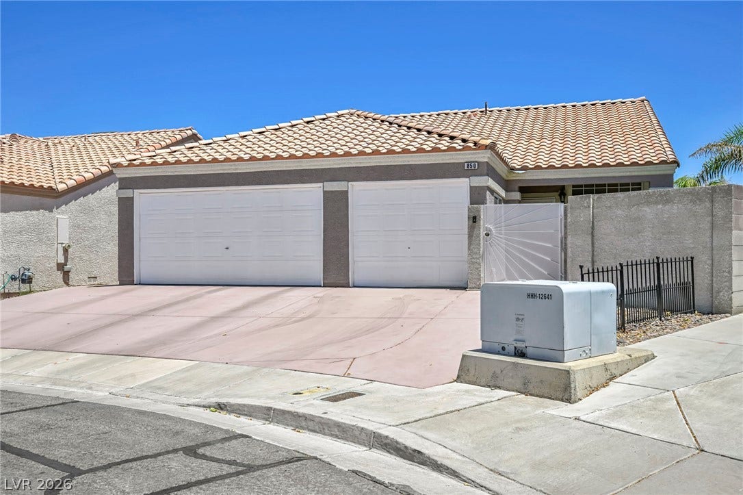 A well-maintained single-story home with an attached two-car garage under a clear sky.