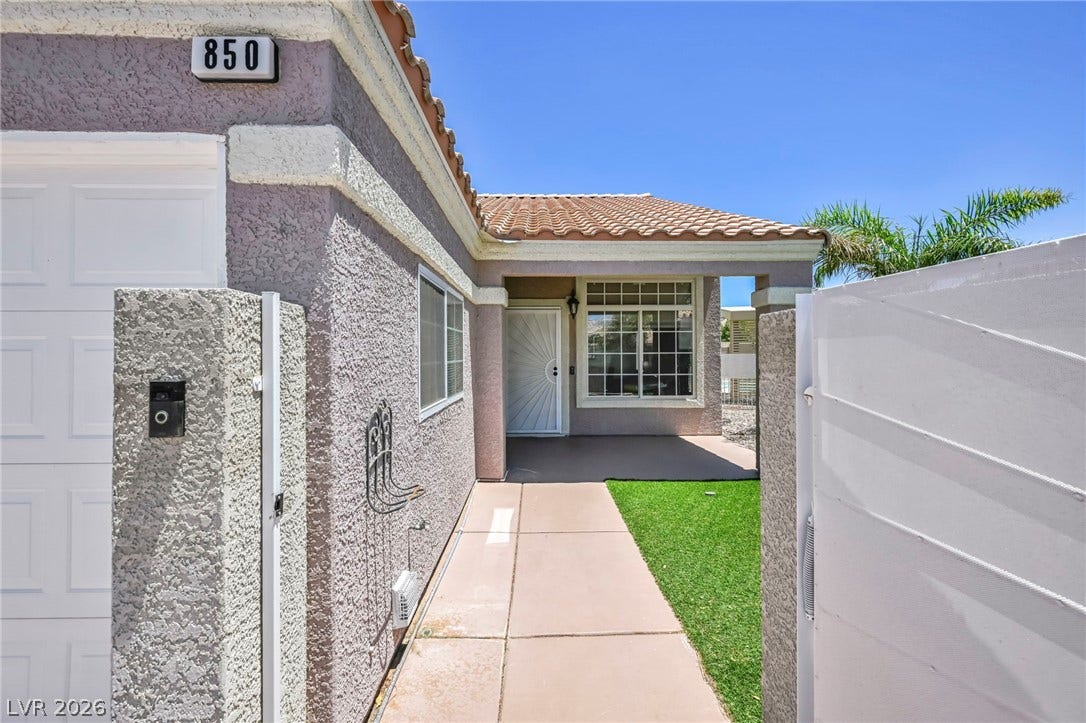 A terracotta-tiled roof and stucco exterior present a charming facade with a welcoming front entrance.