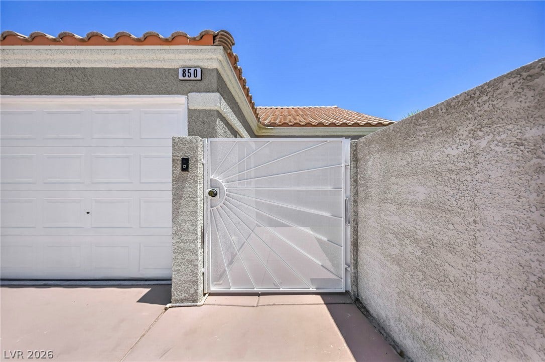 Secure entry point with decorative gate and attached single-car garage.
