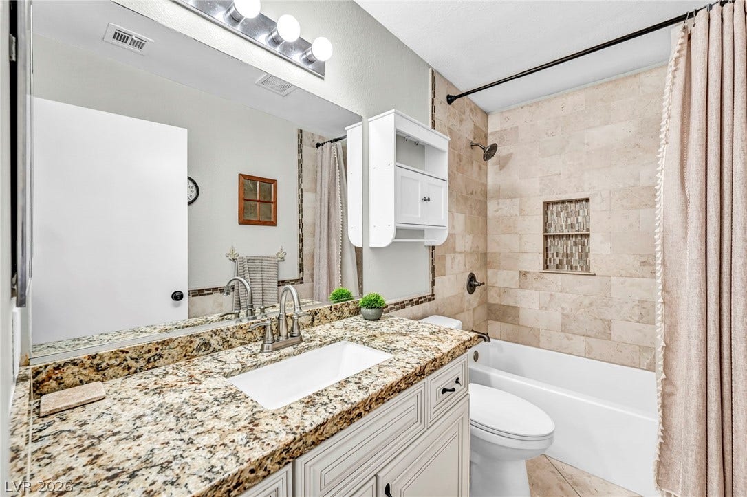 Granite counters and tiled shower walls create a polished, functional bathroom retreat.