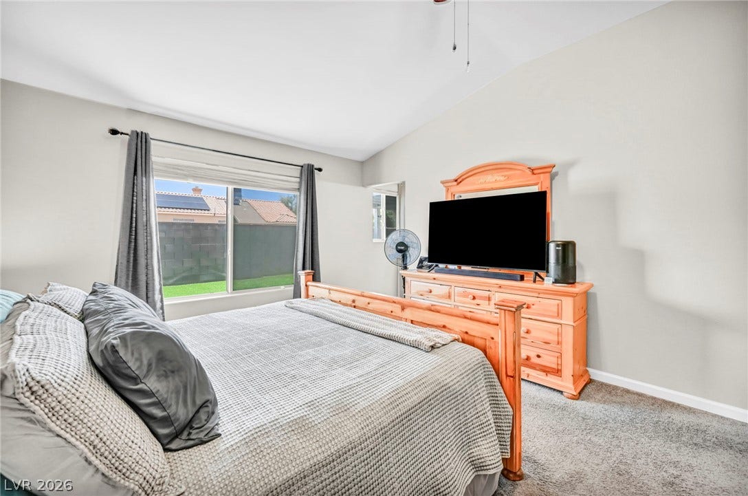 Relax in this tranquil bedroom, featuring plush carpeting and a vaulted ceiling.