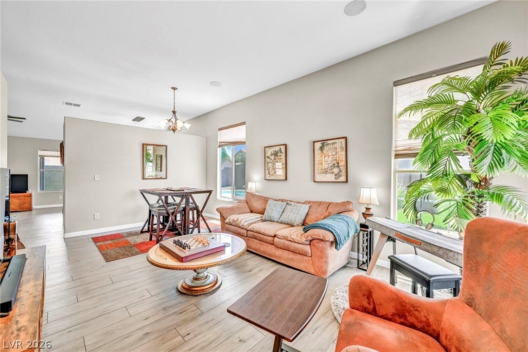 Natural light illuminates an inviting open-concept living space with sleek flooring and backyard pool views.
