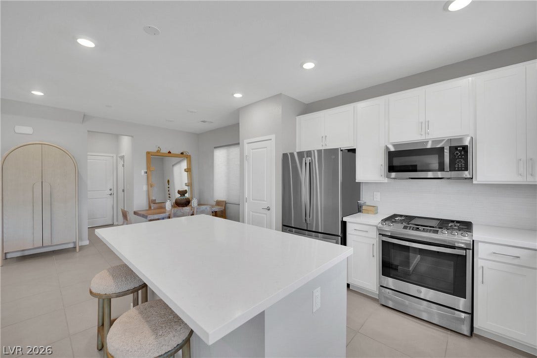 11572 Desert Hollow Avenue, Las Vegas, NV 89138 Prepare meals and entertain in this well-appointed kitchen, featuring a spacious island and modern stainless steel appliances.