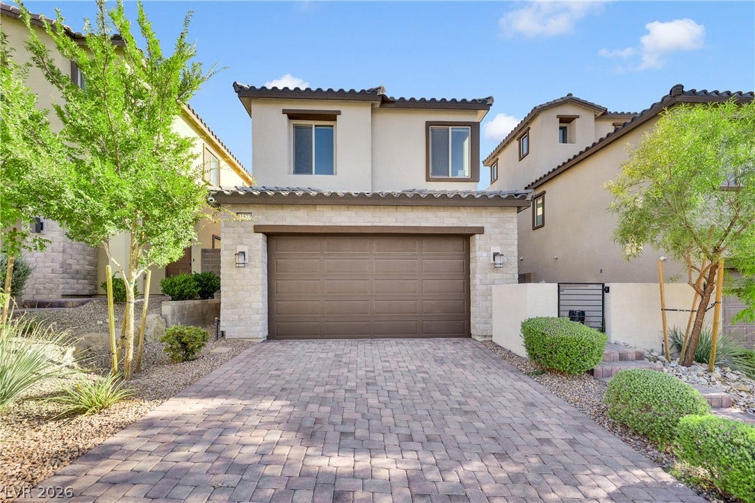11572 Desert Hollow Avenue, Las Vegas, NV 89138 A welcoming paver driveway leads to this charming residence with stone accents and a two-car garage.