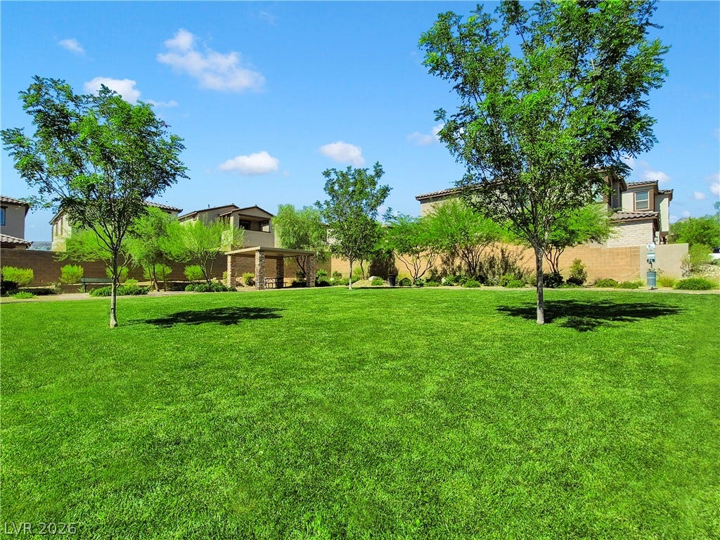 11572 Desert Hollow Avenue, Las Vegas, NV 89138 A verdant community park offers a delightful outdoor escape, complete with mature trees and a shaded gathering area.
