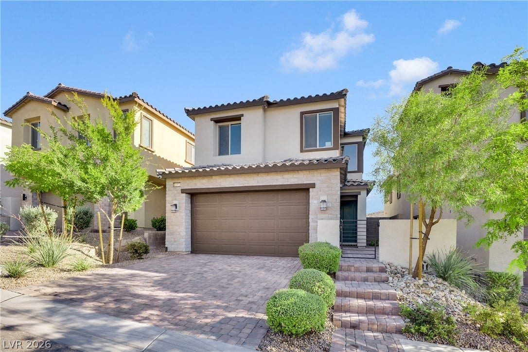 11572 Desert Hollow Avenue, Las Vegas, NV 89138 A well-maintained facade features an attached garage and stone steps leading to the entrance.