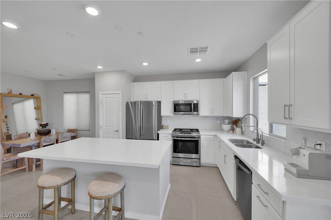 11572 Desert Hollow Avenue, Las Vegas, NV 89138 Culinary delights await in this bright kitchen with a spacious island, pristine countertops, and modern appliances.