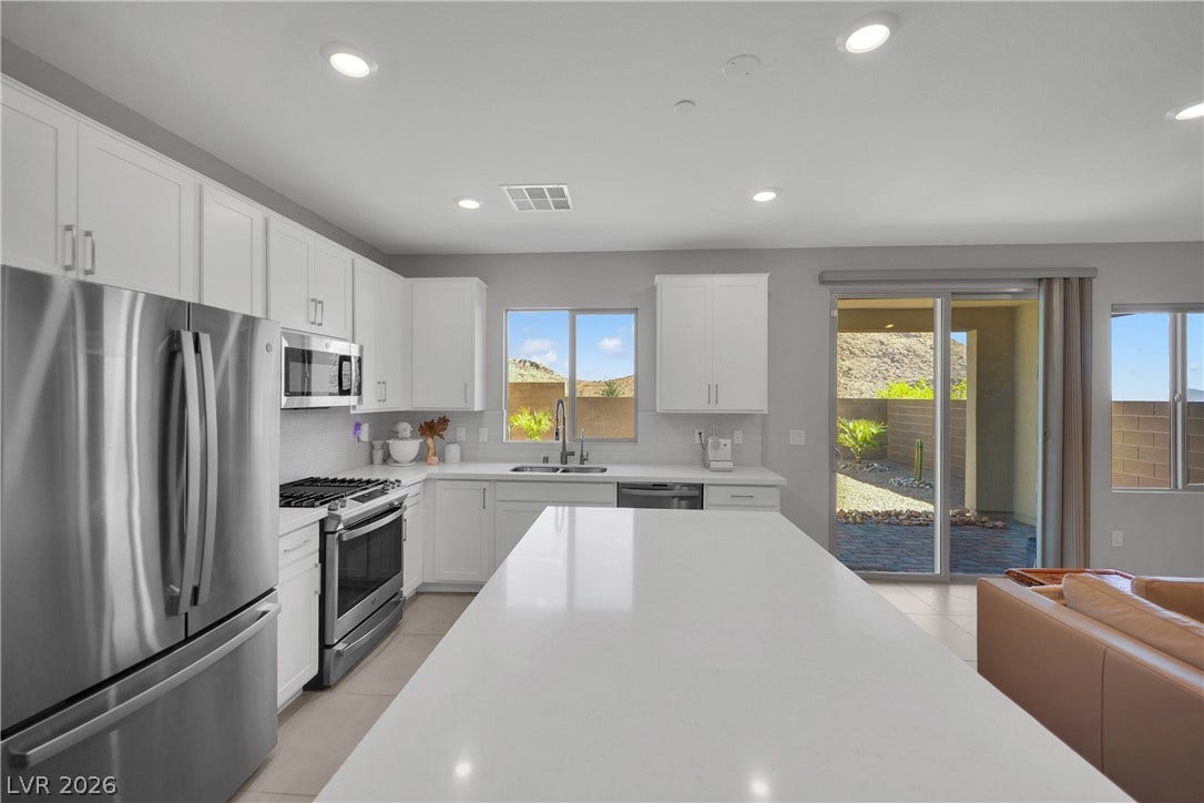 11572 Desert Hollow Avenue, Las Vegas, NV 89138 Culinary delights await in this bright kitchen with a spacious island, modern appliances, and seamless outdoor access.