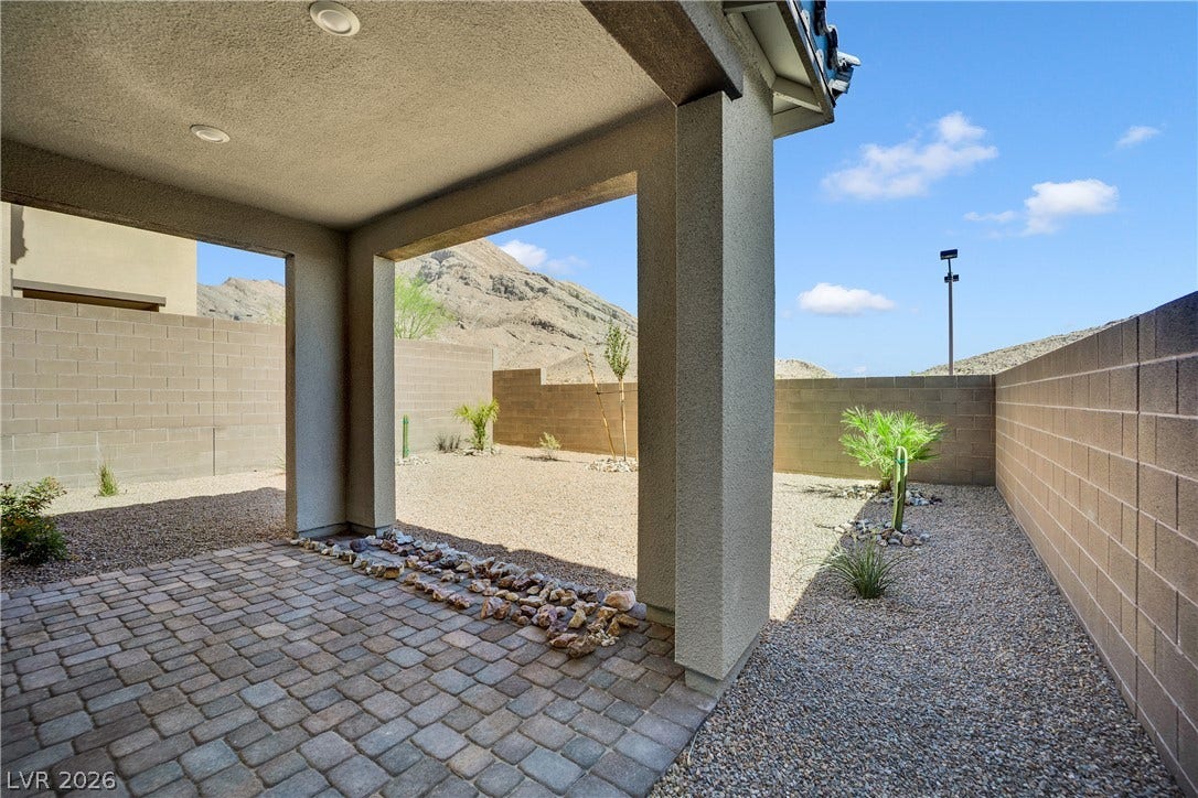 11572 Desert Hollow Avenue, Las Vegas, NV 89138 An inviting covered patio offers a private outdoor retreat with a mountain backdrop.