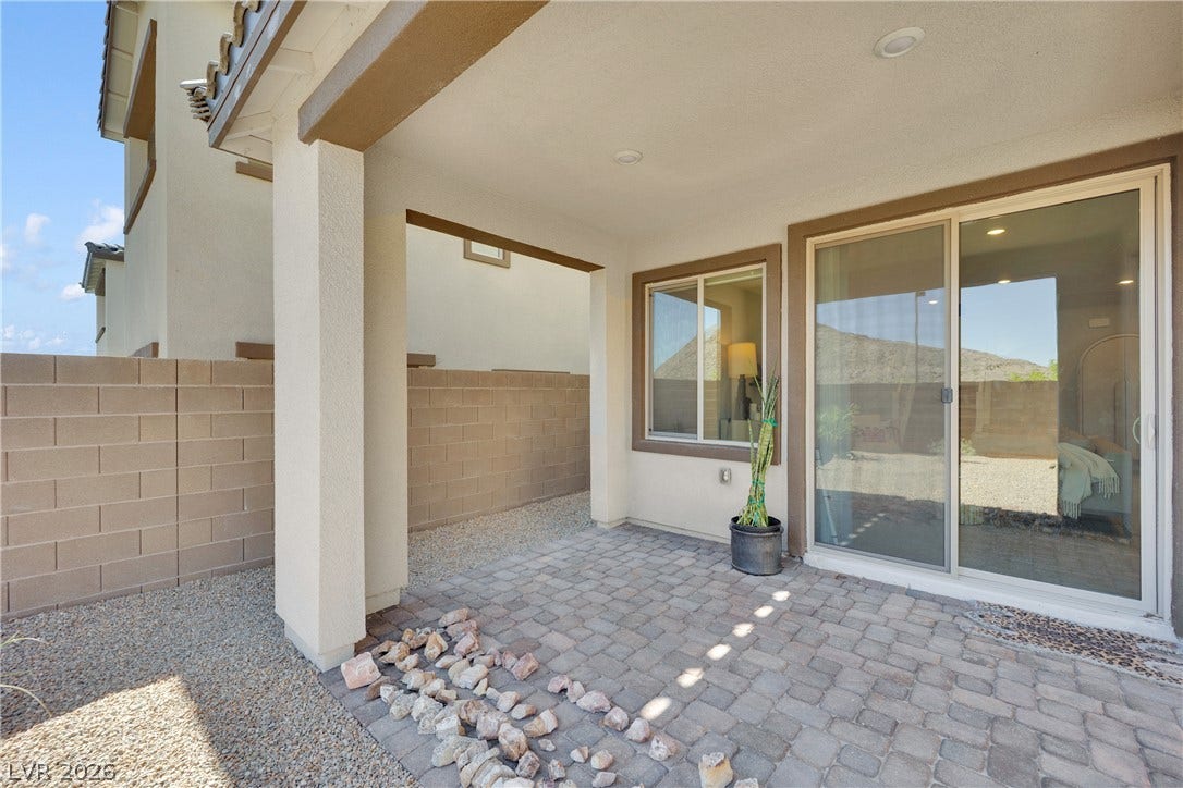 11572 Desert Hollow Avenue, Las Vegas, NV 89138 A private patio space features sturdy block walls and sliding glass doors, perfect for outdoor relaxation.