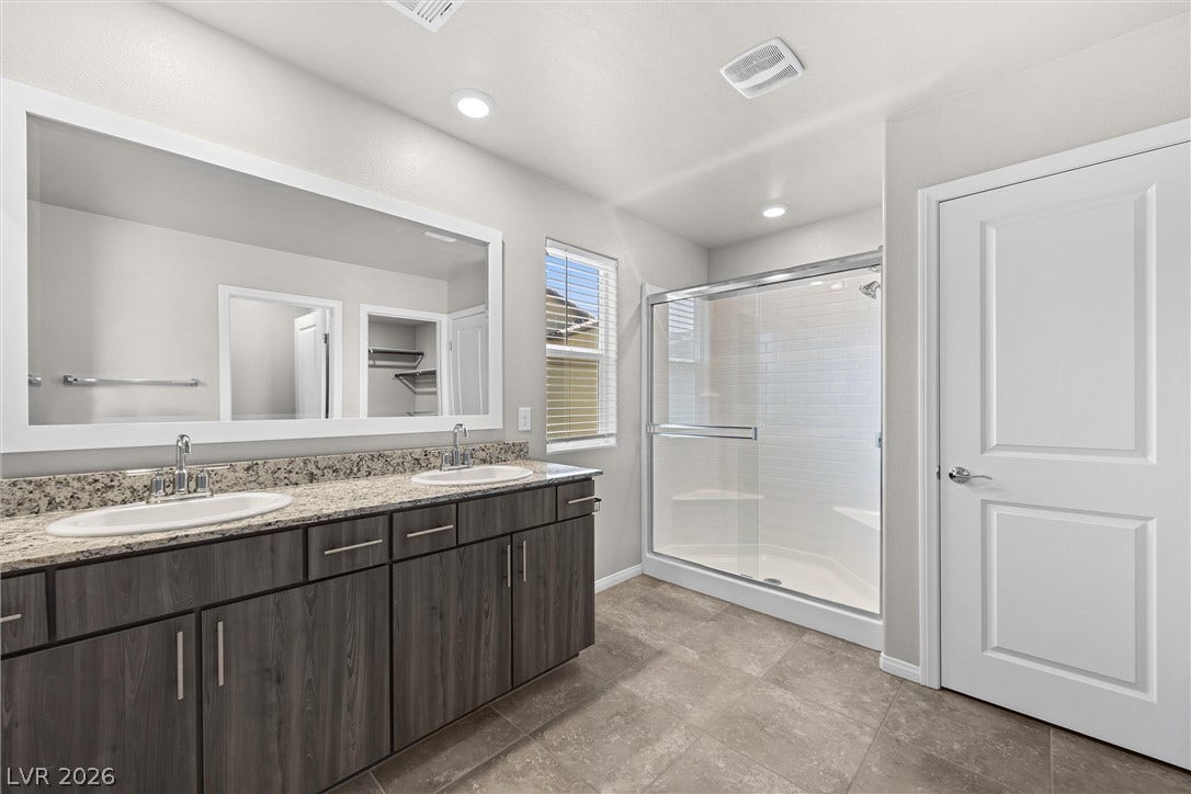 8943 Pelican Point Street, Las Vegas, NV 89178 A well-lit bathroom showcases a dual vanity with ample counter space and a sleek walk-in shower.