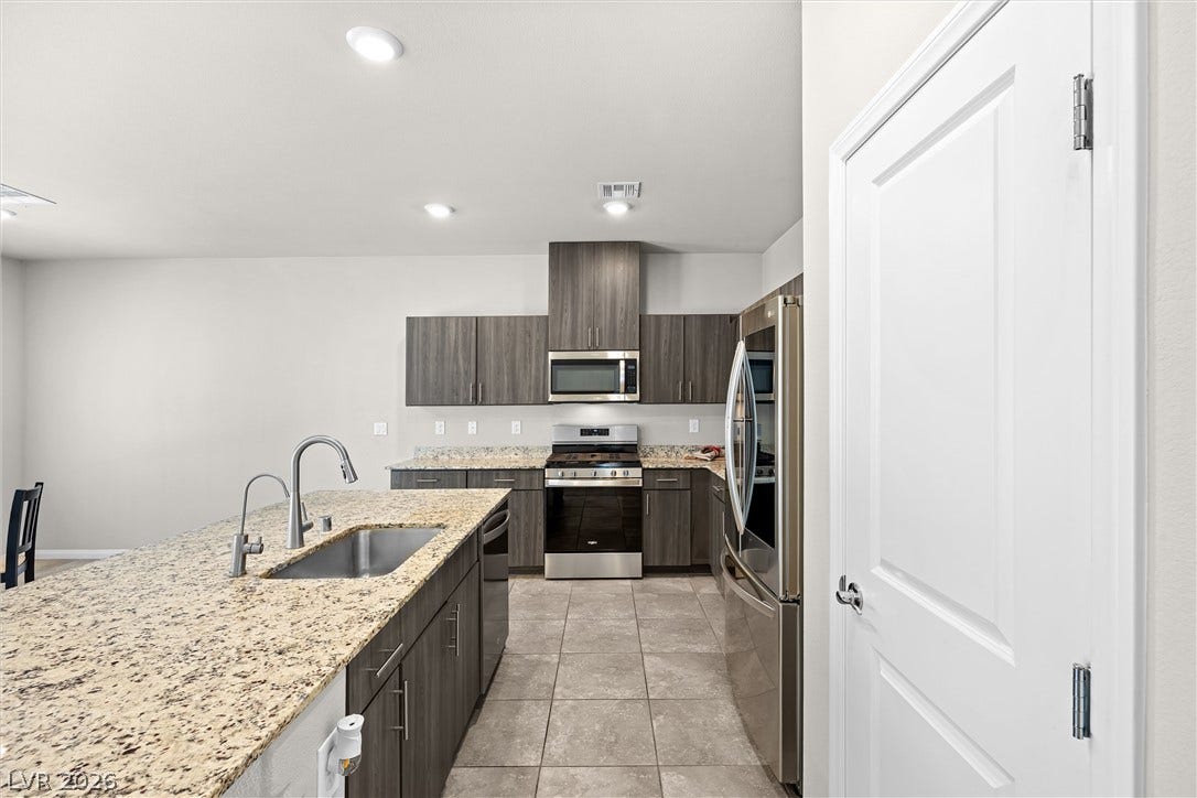 8943 Pelican Point Street, Las Vegas, NV 89178 A well-appointed kitchen showcasing durable granite counters and modern stainless steel appliances.