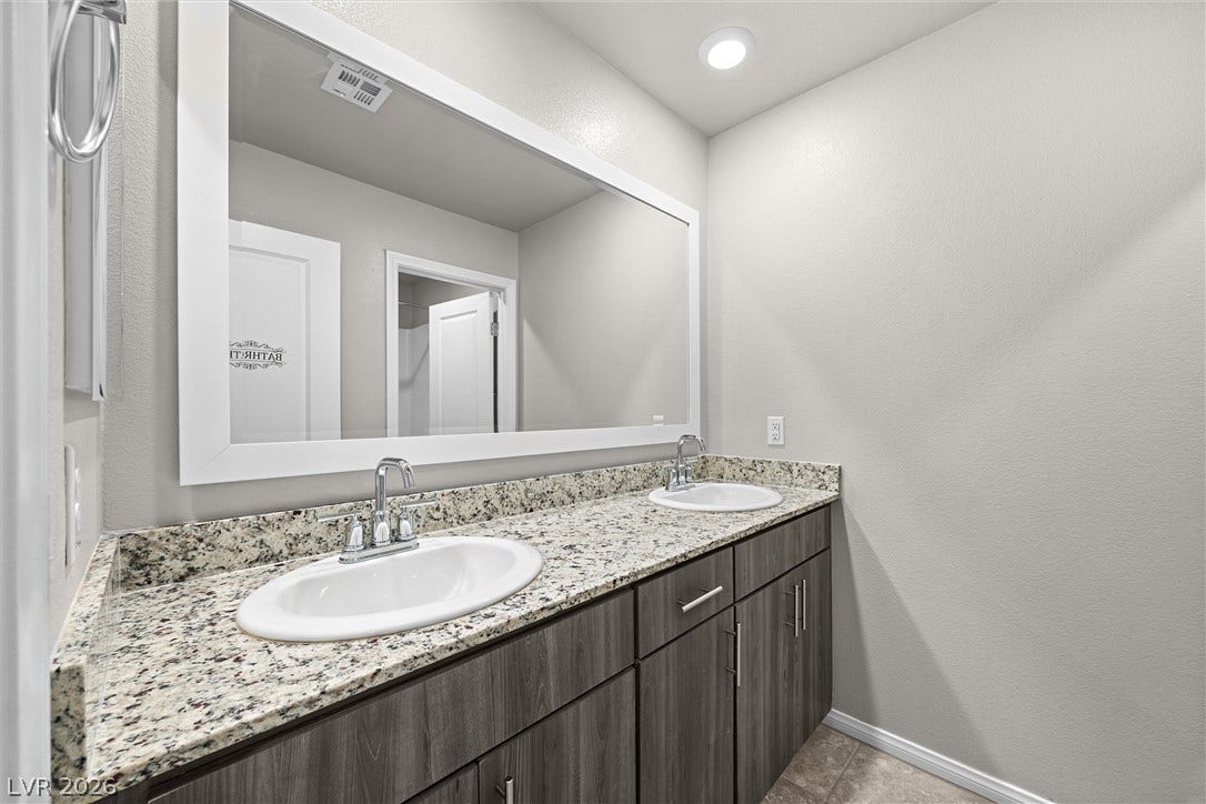 8943 Pelican Point Street, Las Vegas, NV 89178 Double vanities with ample counter space and sleek cabinetry elevate this bathroom's design.