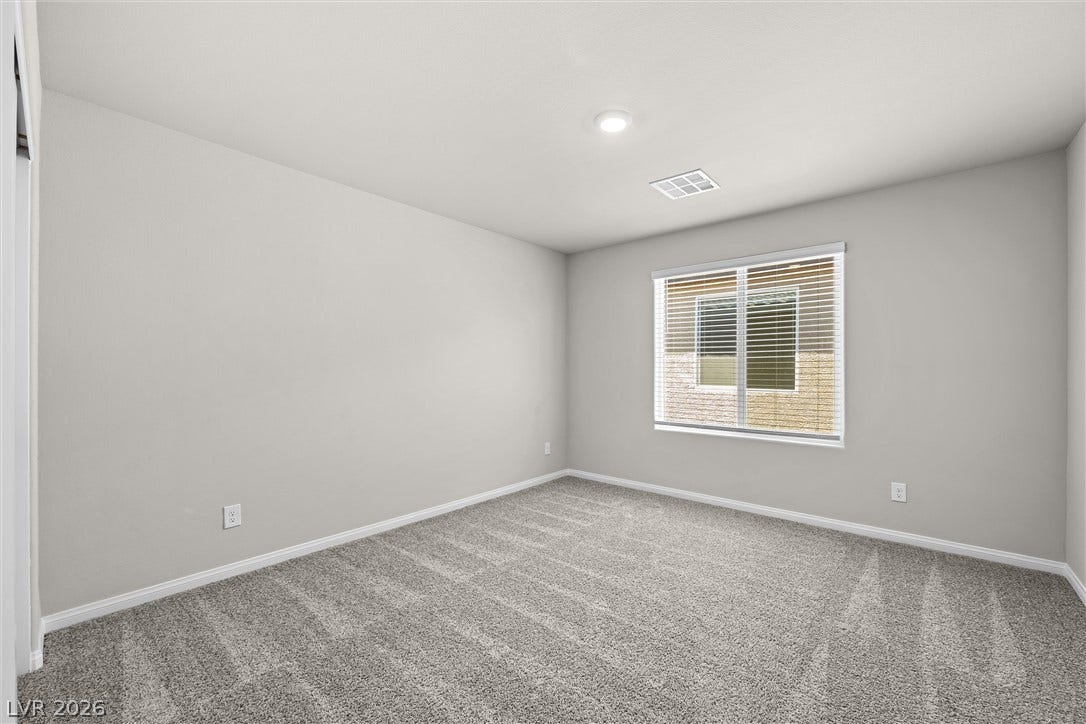 8943 Pelican Point Street, Las Vegas, NV 89178 A well-lit bedroom with plush carpeting, featuring a window dressed with blinds, awaits your personal touch.