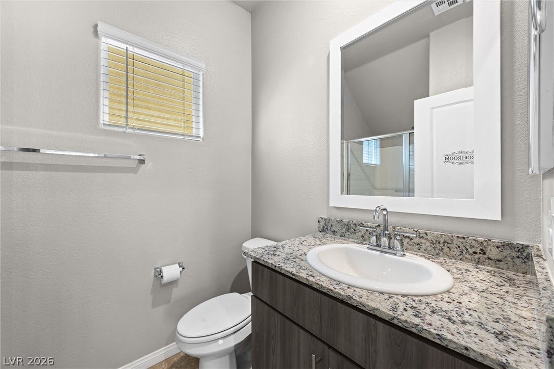 8943 Pelican Point Street, Las Vegas, NV 89178 A well-appointed lavatory boasts a modern vanity with elegant granite counters and a clean, functional design.