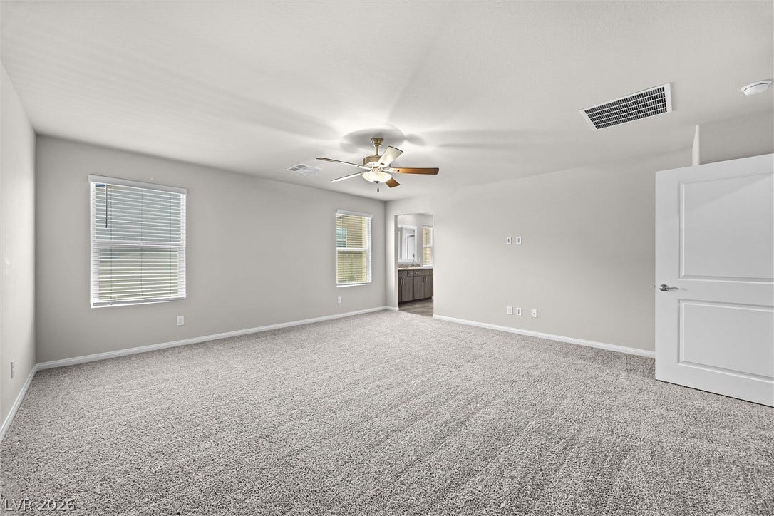 8943 Pelican Point Street, Las Vegas, NV 89178 A spacious, naturally illuminated room features plush carpeting and a modern ceiling fan for comfort.