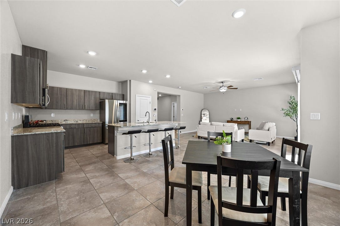 8943 Pelican Point Street, Las Vegas, NV 89178 An open-concept living space features an inviting kitchen island and a well-lit dining area, perfect for gatherings.