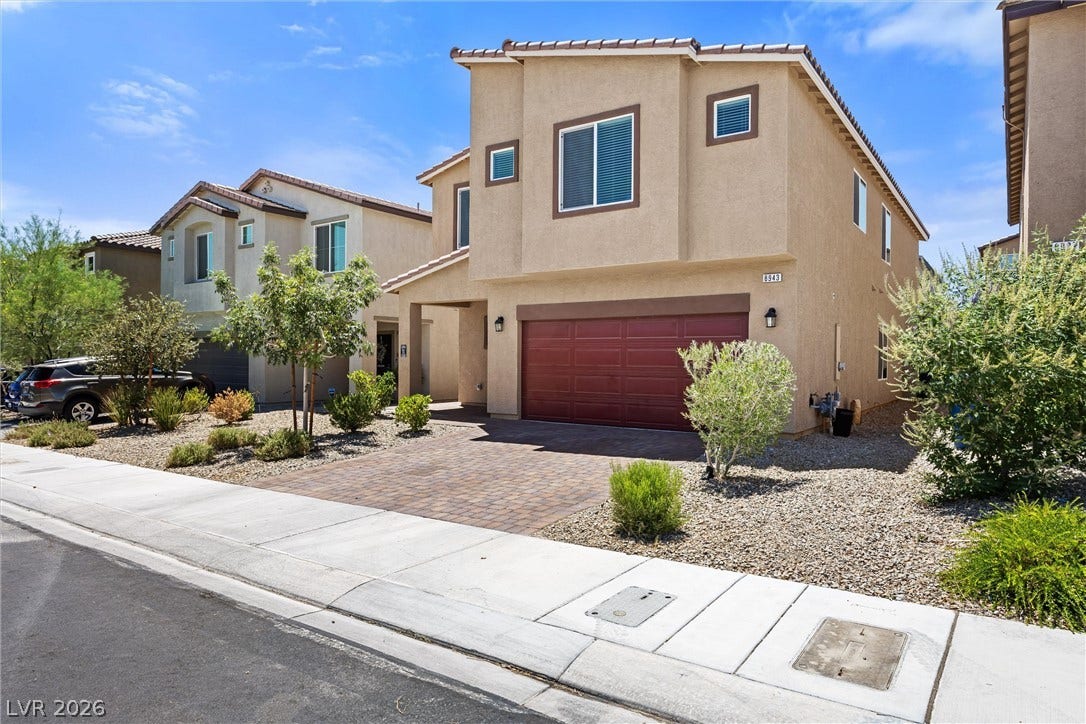 8943 Pelican Point Street, Las Vegas, NV 89178 A well-maintained desert landscape frames this welcoming residence, featuring an attached garage and a neatly paved driveway.