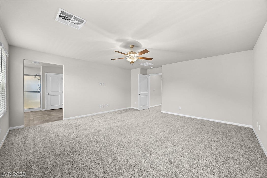 8943 Pelican Point Street, Las Vegas, NV 89178 A spacious primary bedroom featuring plush carpeting and an adjoining primary bath.