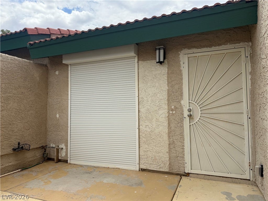 Secure entry point featuring a robust security door and roll-down shutter.