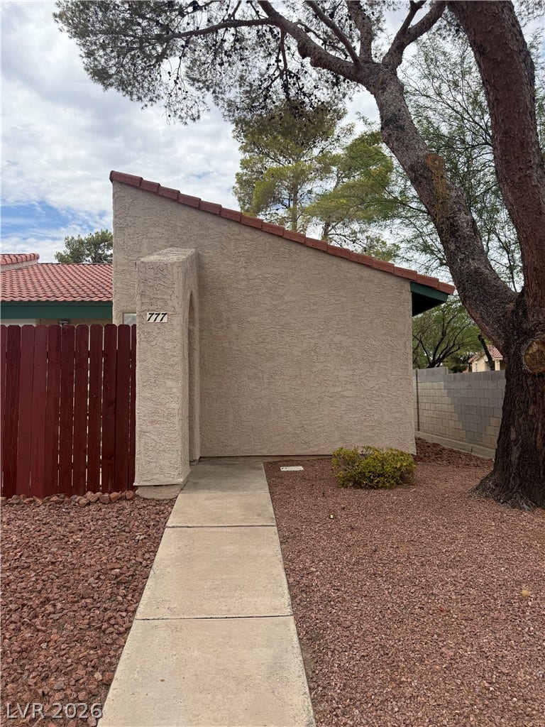 A terracotta-tiled roof crowns this stucco home, offering a blend of durability and visual appeal.