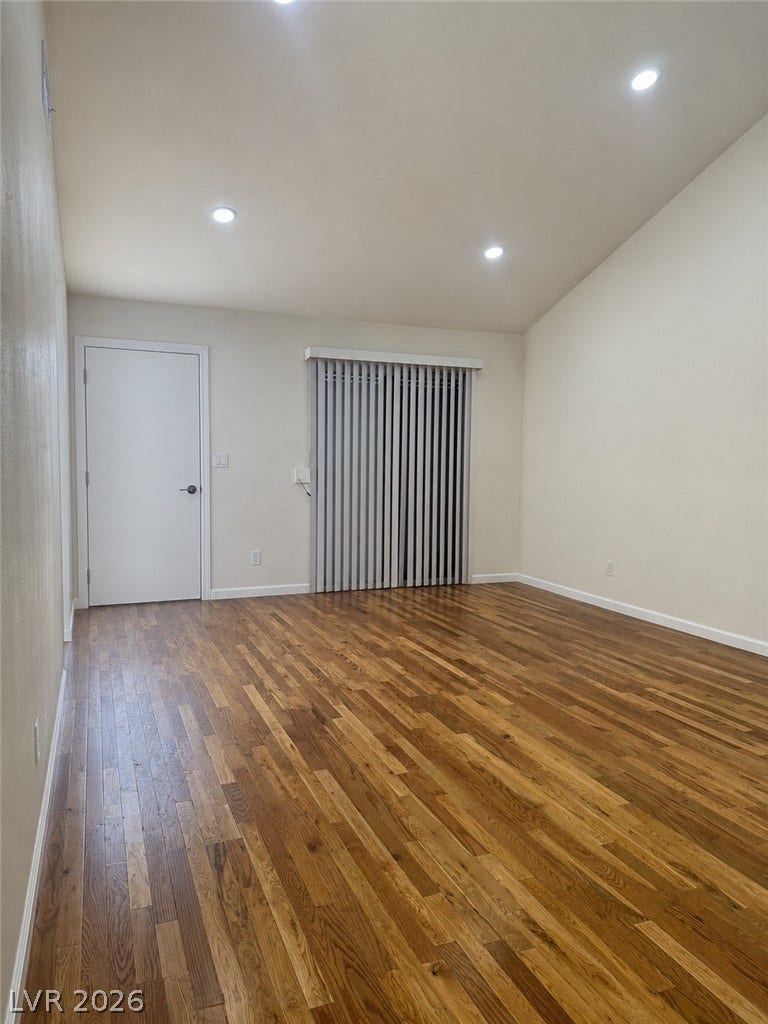 Rich hardwood floors flow through this luminous space, complemented by recessed lighting.