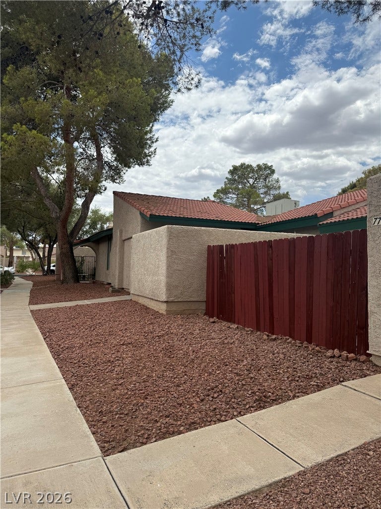 Mature trees frame this inviting residence, featuring a well-maintained exterior and practical landscaping.