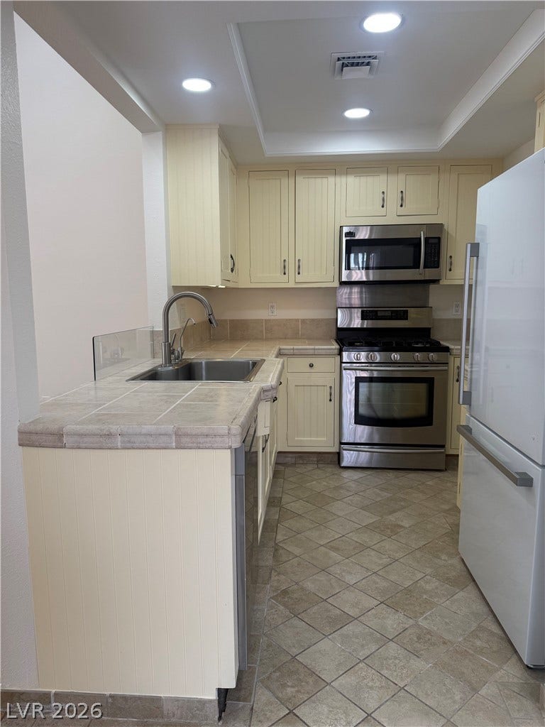 A well-appointed kitchen features stainless steel appliances and a tiled floor.