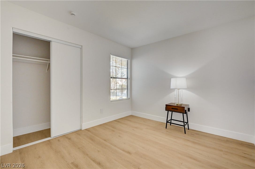3131 White Rose Way, Henderson, NV 89014 Blinds adorn the window in this cozy room, featuring light hardwood flooring and a functional closet.