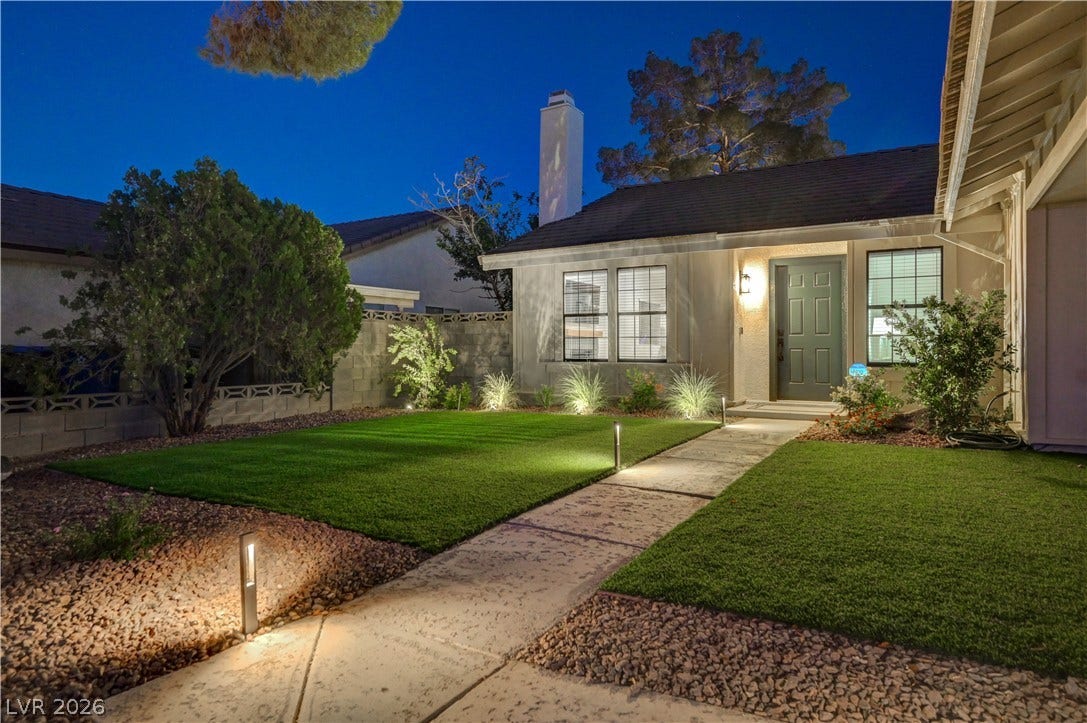 3131 White Rose Way, Henderson, NV 89014 Illuminated walkway leads to a welcoming entry with well-maintained landscaping.