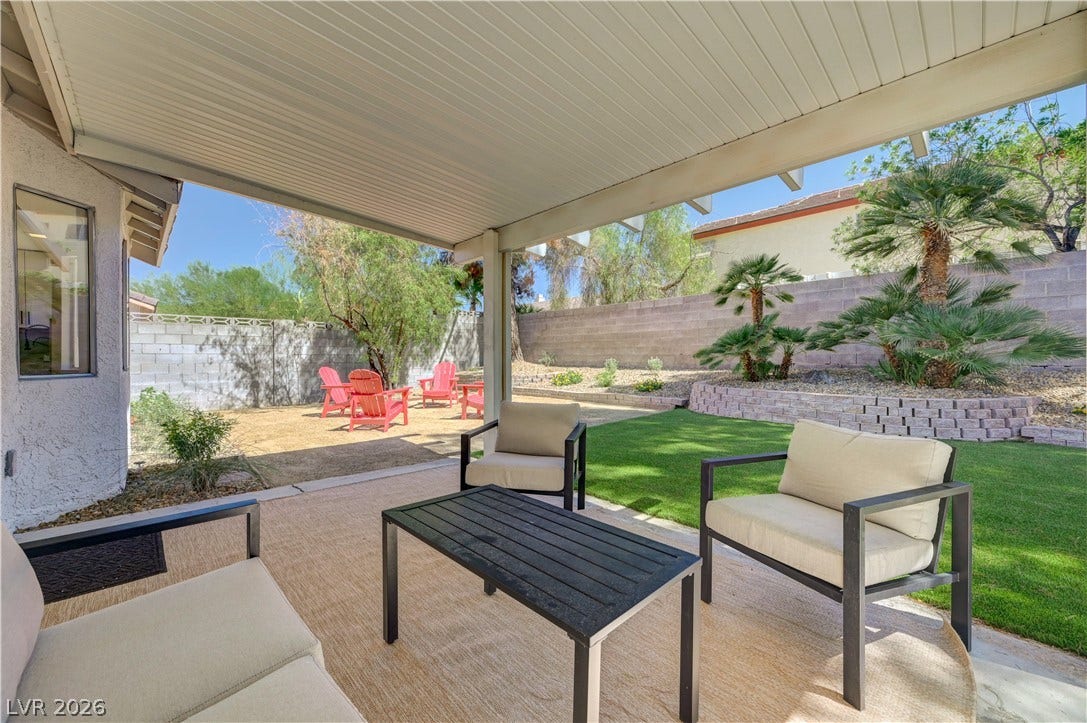 3131 White Rose Way, Henderson, NV 89014 An inviting covered patio opens to a split yard, featuring both artificial turf and natural landscaping for diverse outdoor enjoyment.