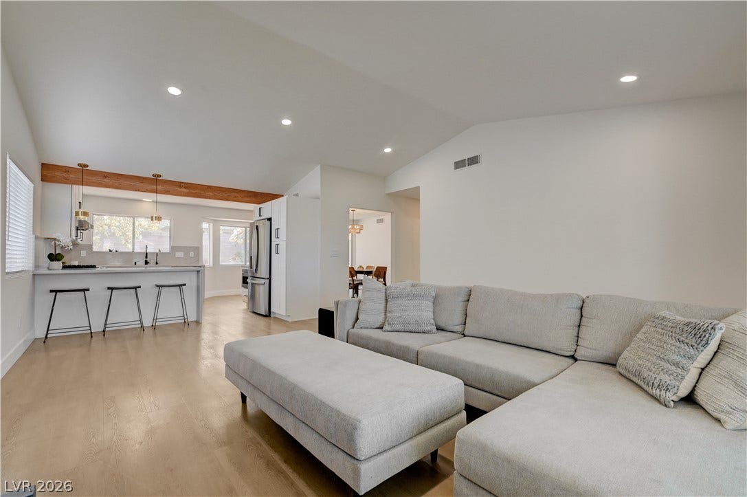 3131 White Rose Way, Henderson, NV 89014 Natural light illuminates an inviting open-concept living space with sleek hardwood flooring.