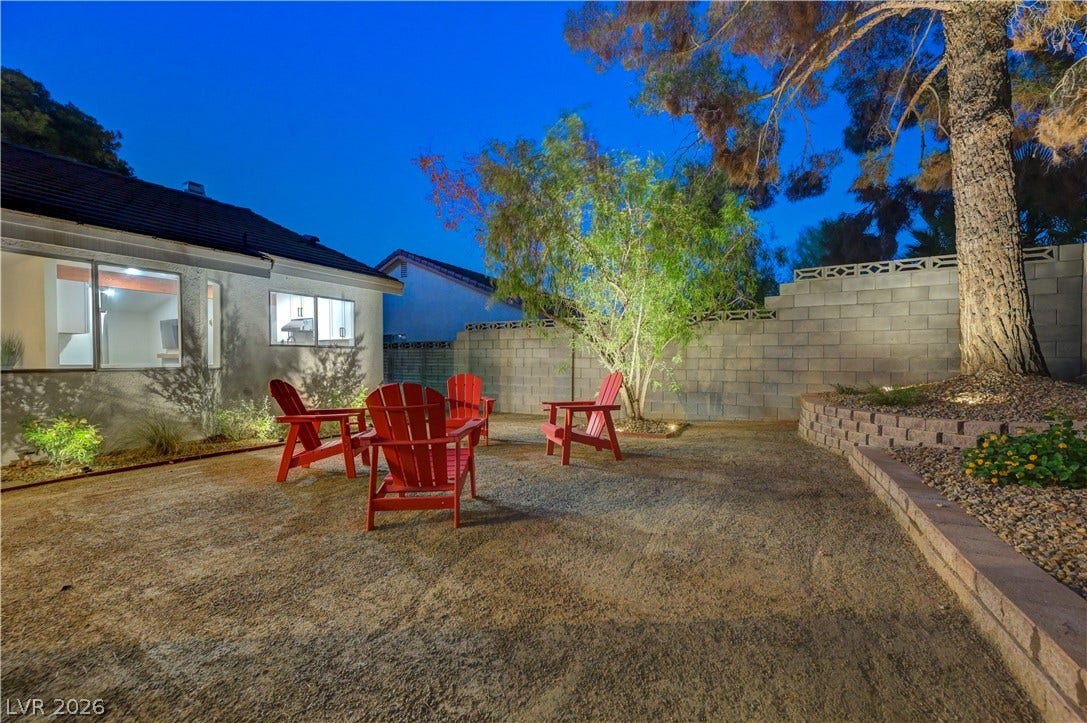 3131 White Rose Way, Henderson, NV 89014 A private yard offers a tranquil retreat with mature trees and a seating area for evening gatherings.