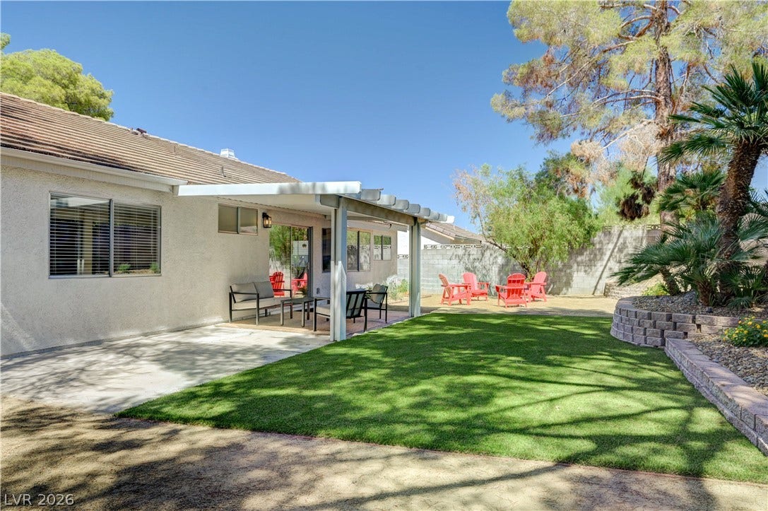 3131 White Rose Way, Henderson, NV 89014 Lush green lawn and a covered patio create a perfect outdoor entertaining space.