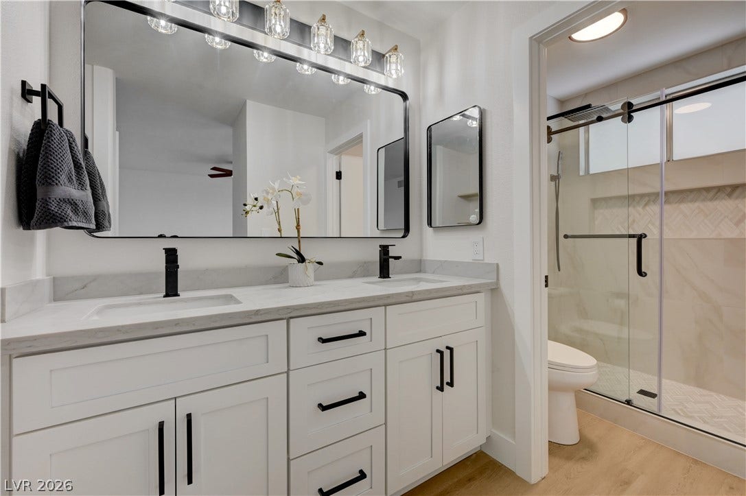 3131 White Rose Way, Henderson, NV 89014 A well-appointed bathroom features a double vanity and a glass-enclosed shower, marrying form and function.