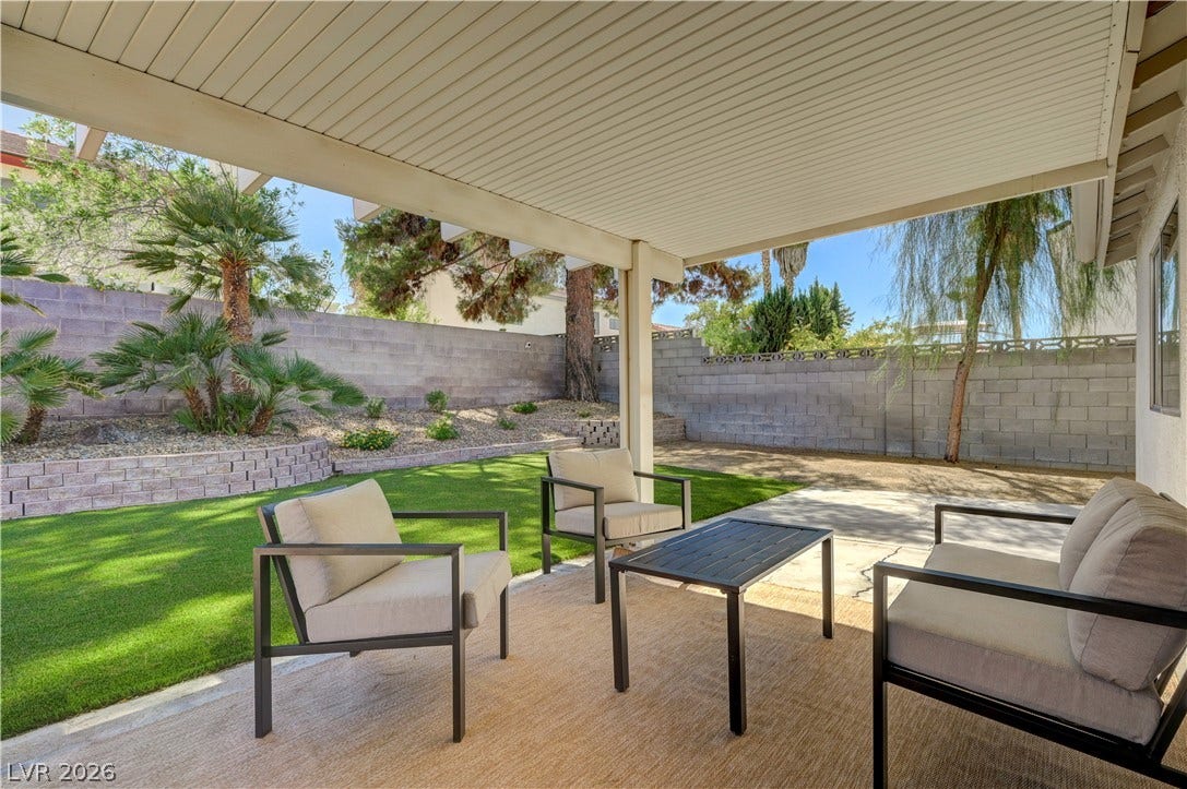 3131 White Rose Way, Henderson, NV 89014 A spacious covered patio invites relaxation, overlooking a manicured yard with mature landscaping.