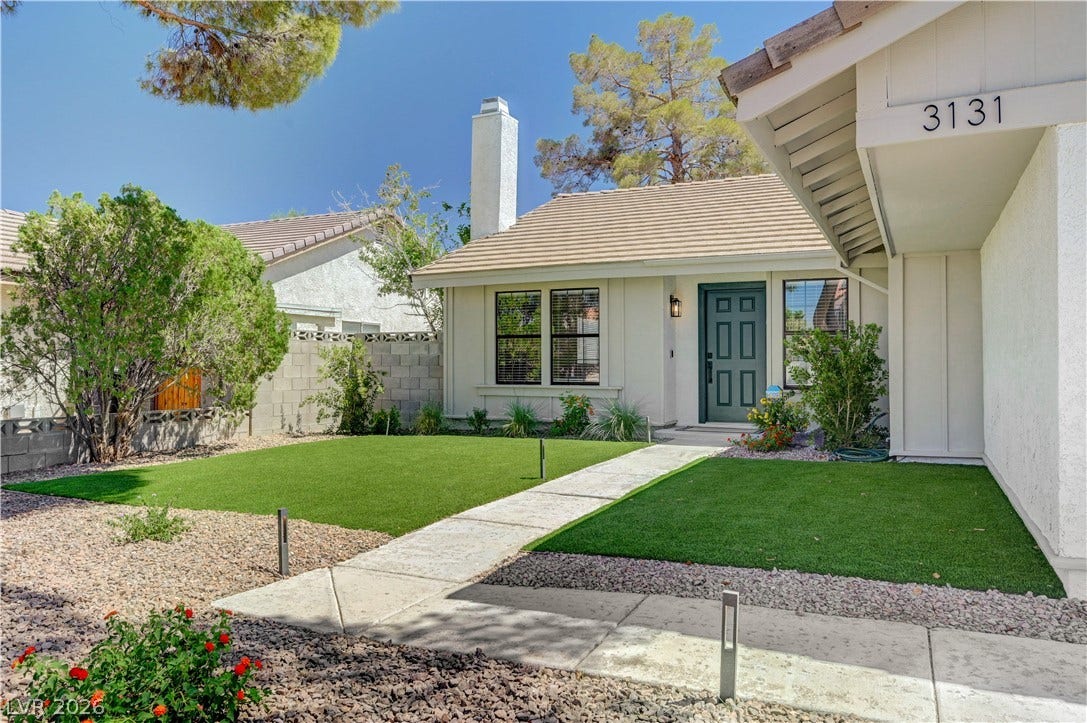 3131 White Rose Way, Henderson, NV 89014 A welcoming facade with manicured artificial turf and decorative gravel landscaping awaits.