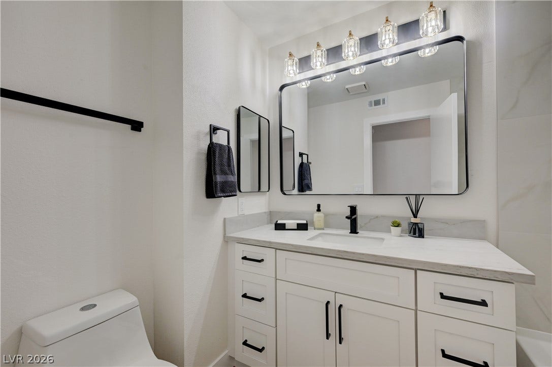 3131 White Rose Way, Henderson, NV 89014 A well-appointed bathroom features a modern vanity with elegant hardware and a bright overhead light fixture.