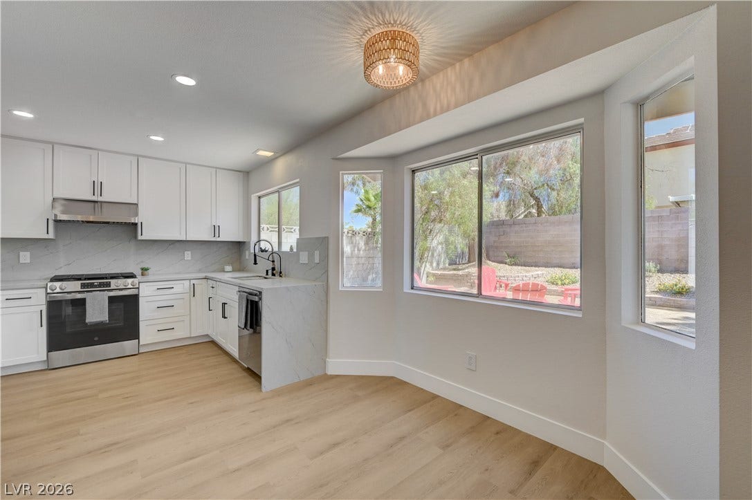 3131 White Rose Way, Henderson, NV 89014 Modern kitchen with sleek cabinetry and sunlit dining nook.