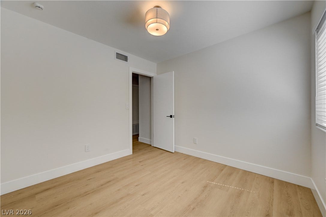 3131 White Rose Way, Henderson, NV 89014 Luminous room featuring durable hardwood flooring and a functional closet for organized living.
