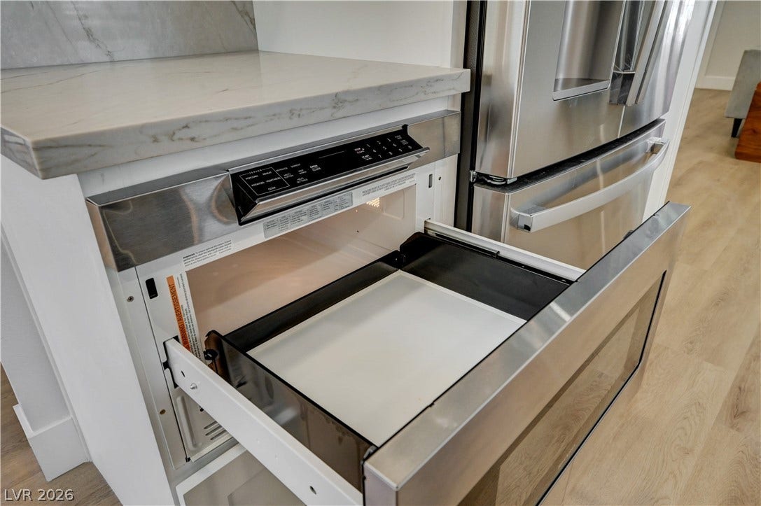 3131 White Rose Way, Henderson, NV 89014 Modern kitchen equipped with a stainless steel microwave drawer and refrigerator for culinary convenience.