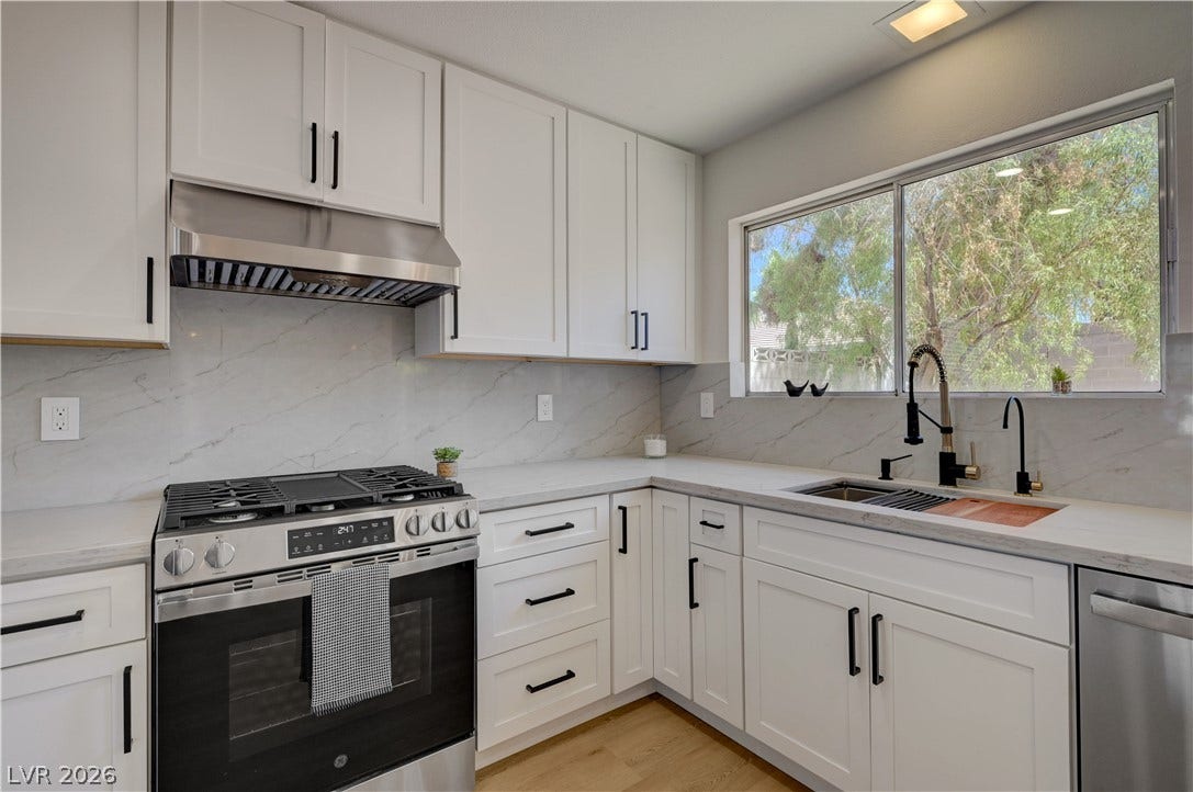 3131 White Rose Way, Henderson, NV 89014 Modern kitchen with white cabinetry and light-toned countertops creates a sleek and inviting culinary space.