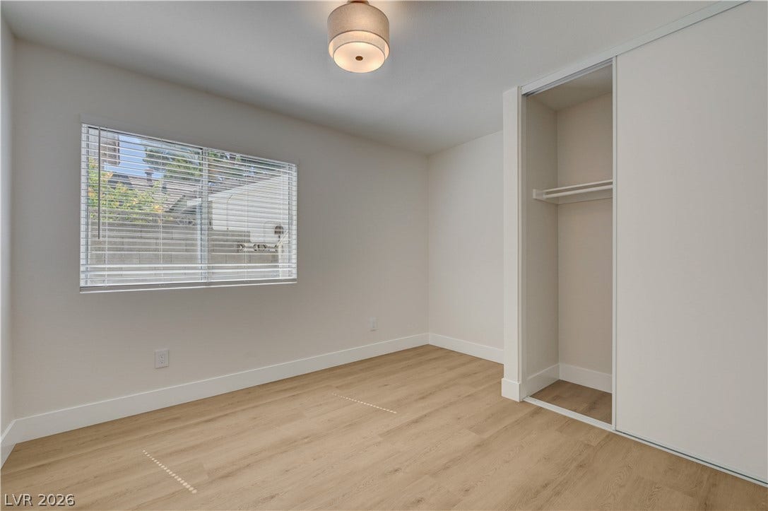 3131 White Rose Way, Henderson, NV 89014 Clean lines define this bright bedroom, featuring light-toned flooring and an integrated closet.