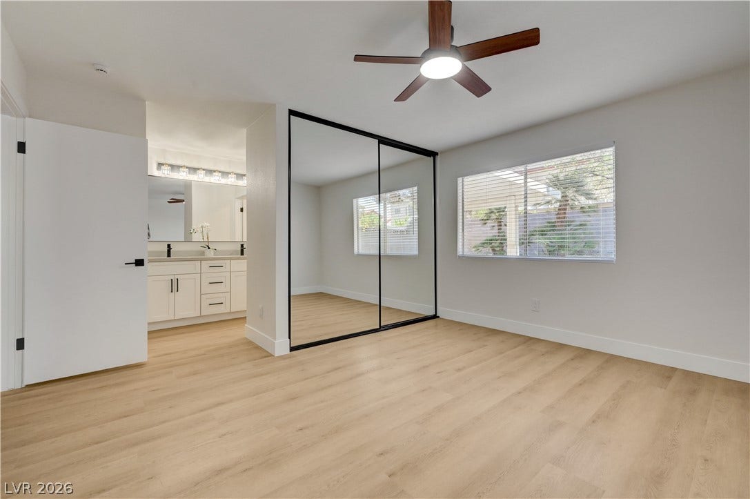 3131 White Rose Way, Henderson, NV 89014 A well-lit bedroom features light wood flooring and a refreshing ceiling fan.