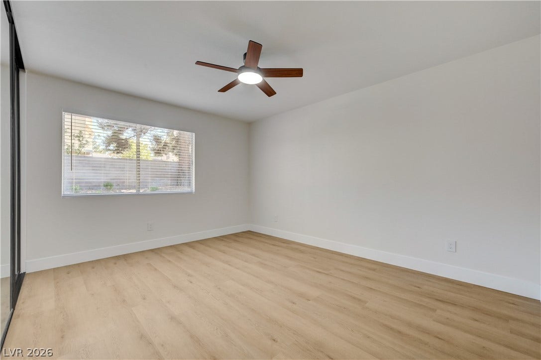 3131 White Rose Way, Henderson, NV 89014 A quiet bedroom offers serene wood flooring and a modern ceiling fan for ultimate comfort.