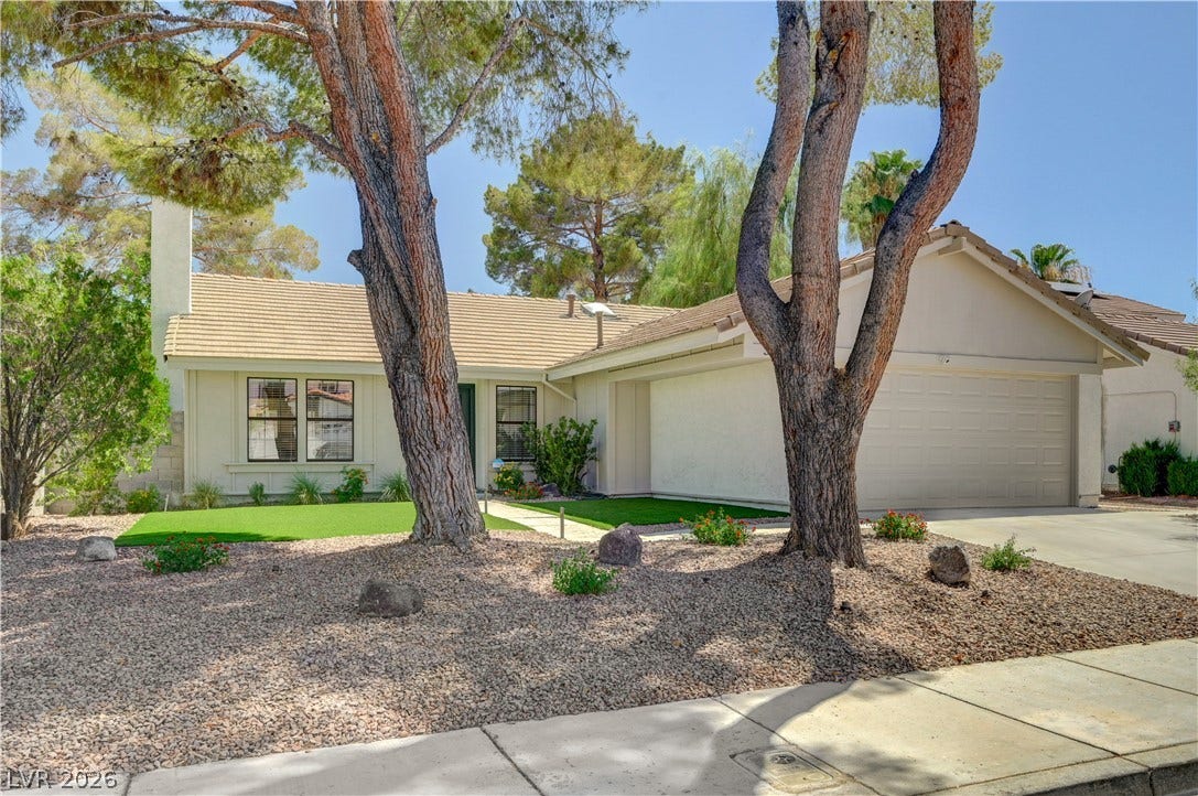 3131 White Rose Way, Henderson, NV 89014 A well-maintained facade with mature trees and a manicured lawn invites you into this appealing residence.