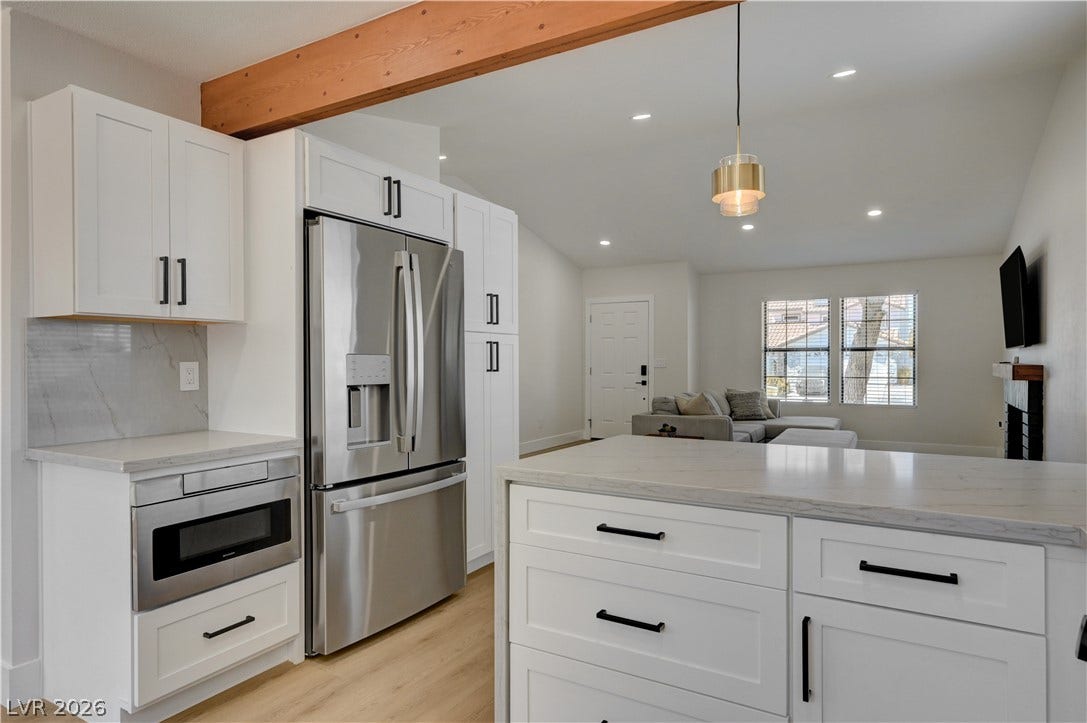 3131 White Rose Way, Henderson, NV 89014 A well-lit kitchen with sleek stainless steel appliances and a spacious island flows into the living area.
